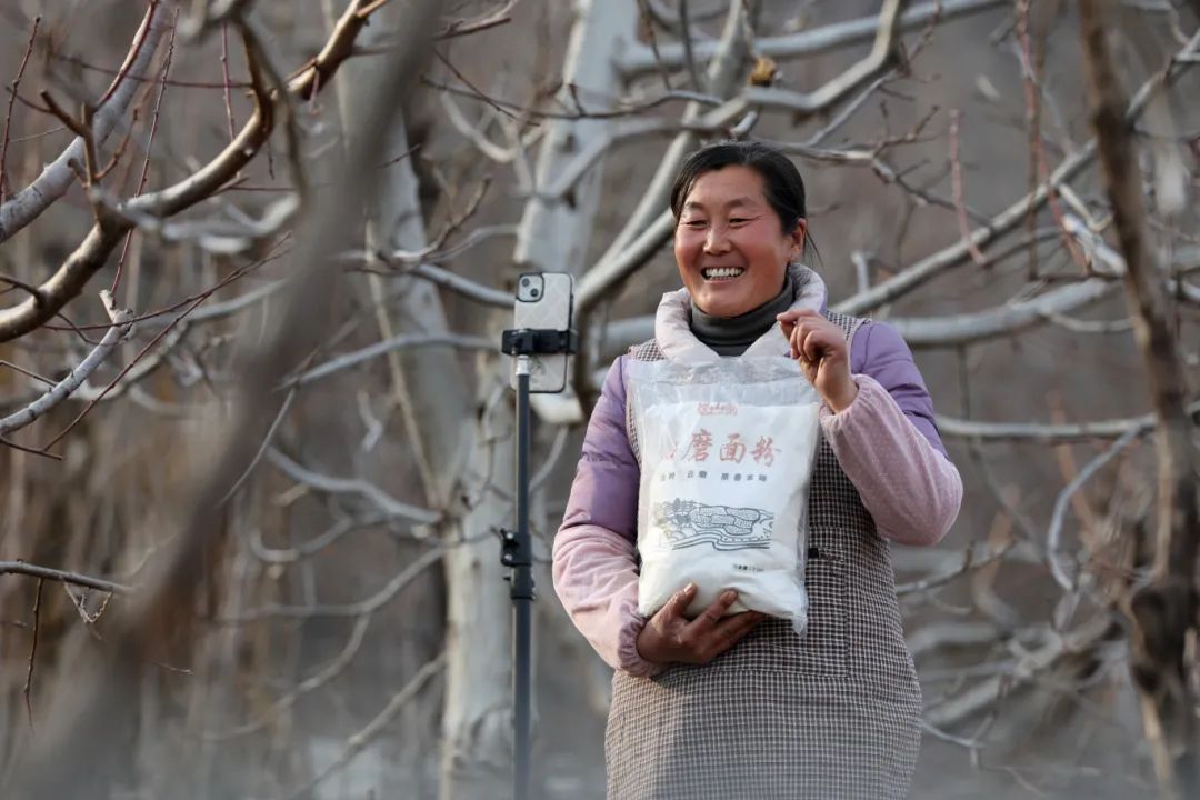 吕玉霞在桃树林直播介绍家乡土特产 （蒙阴宣传部供图）.jpg