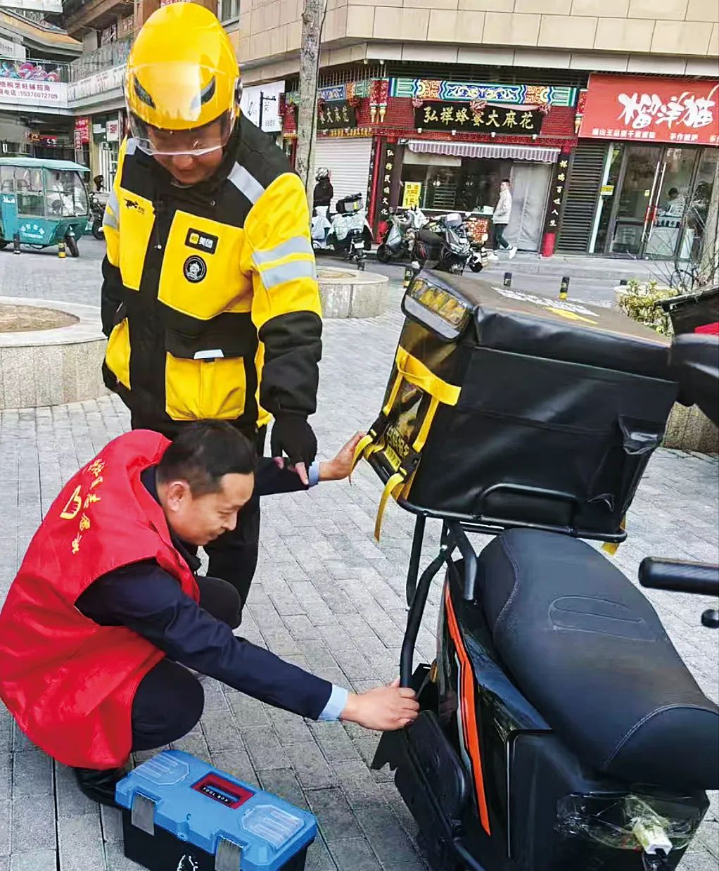 巩云锋帮助骑手修理电动车.jpg